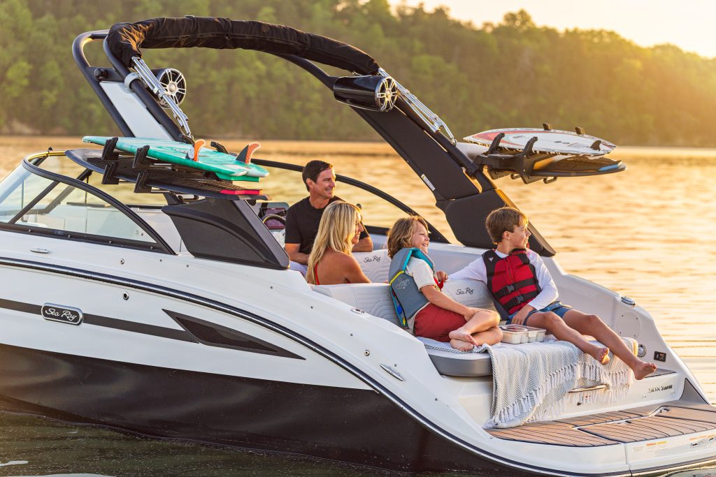 Family aboard an SDX 230 Surf at sunset