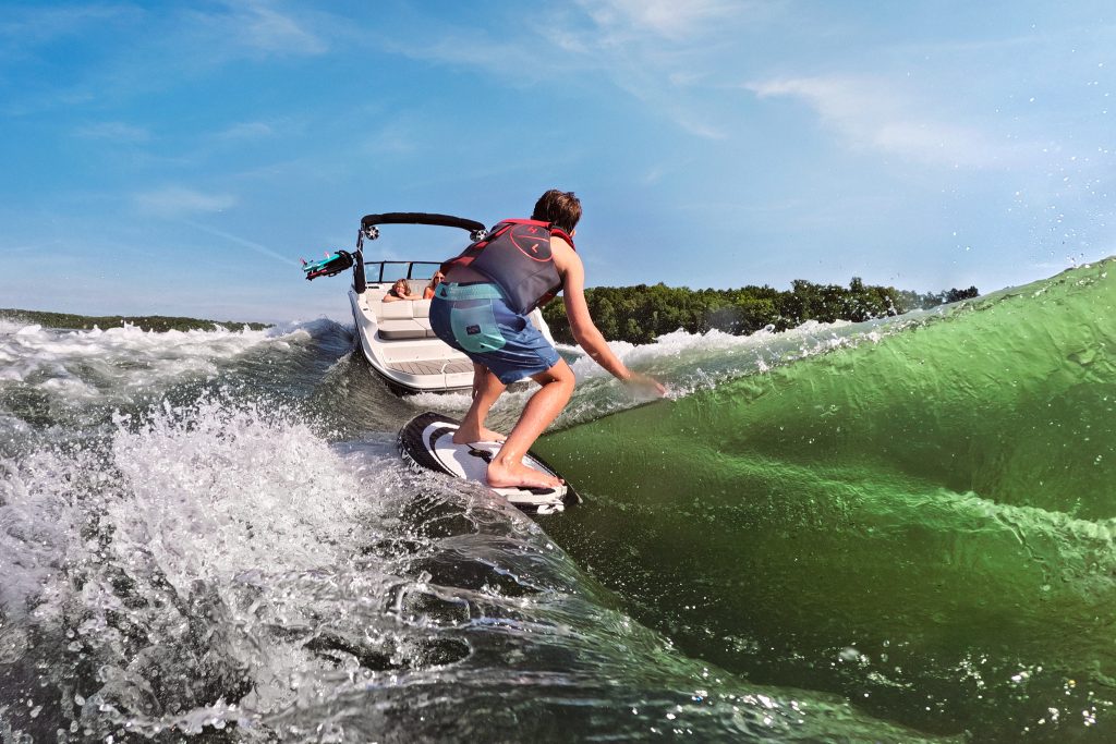 Kid wakesurfing behind an SDX 230 Surf