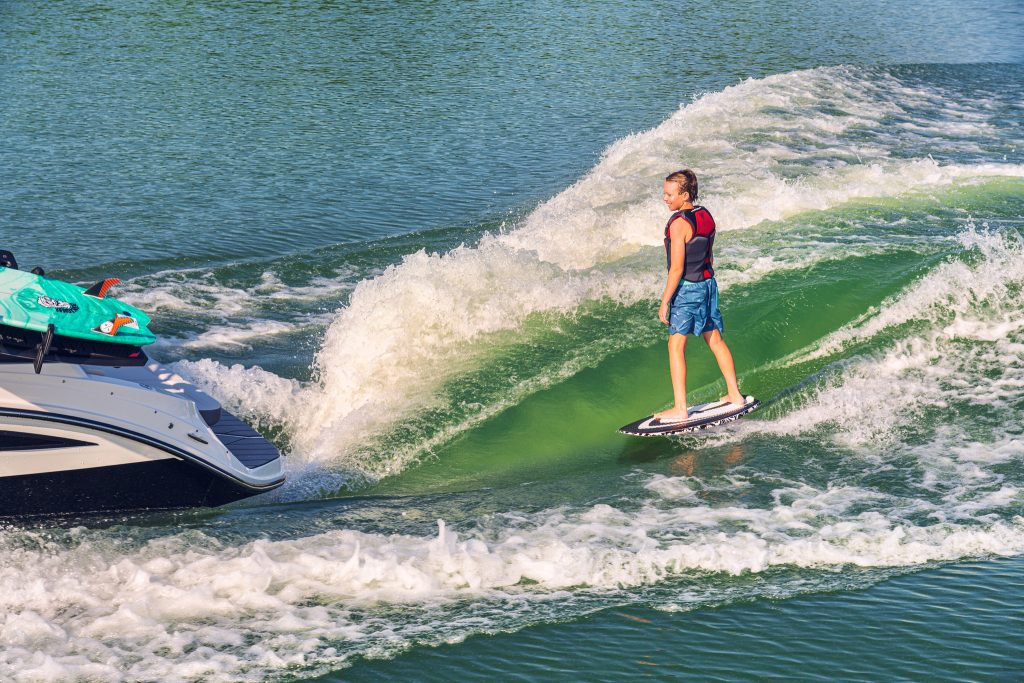 Kid wakesurfing behind an SDX 230 Surf