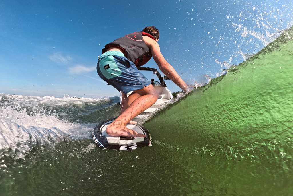 Kid wakesurfing behind an SDX 230 Surf