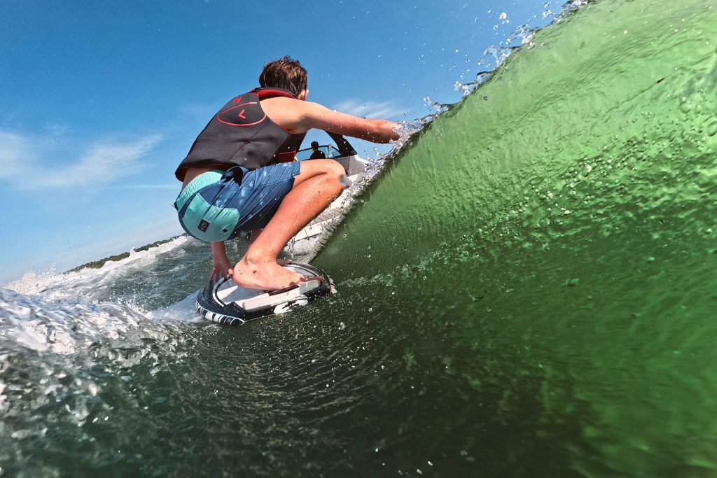 Kid wakesurfing behind an SDX 230 Surf