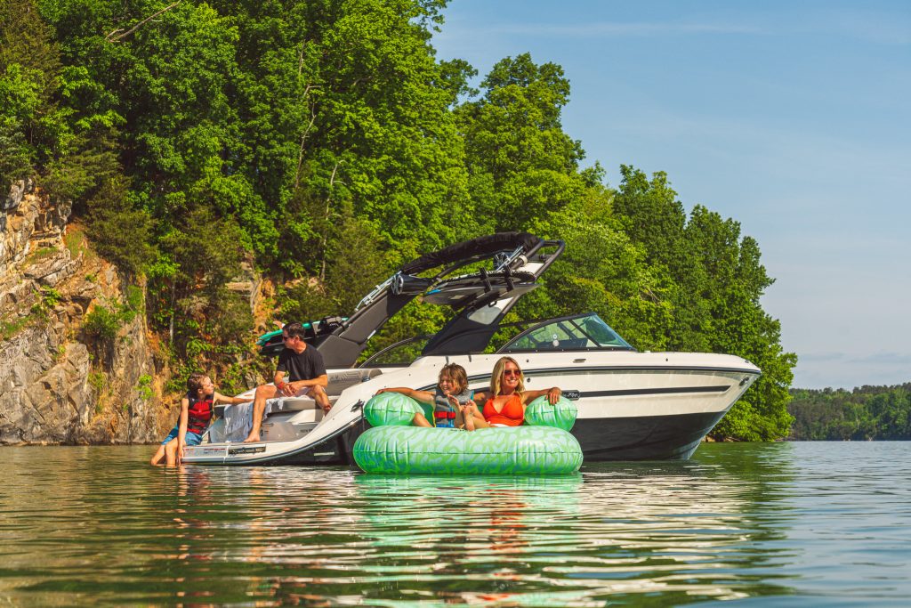 Mother and son floating on an inflatable next to an SDX 230 Surf