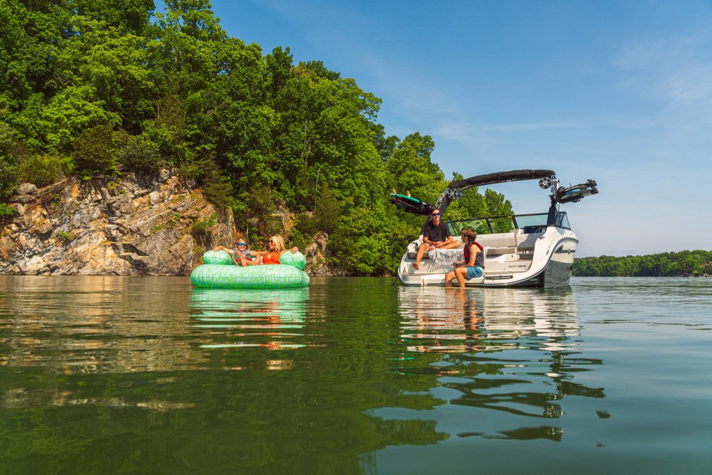 Mother and son floating on an inflatable next to an SDX 230 Surf