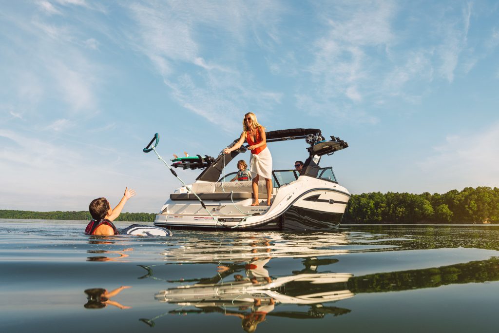 Woman throwing a wakesurfing tow line aboard an SDX 230 Surf