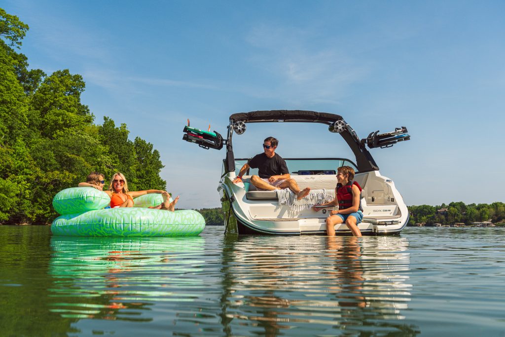 Mother and son floating on an inflatable next to an SDX 230 Surf