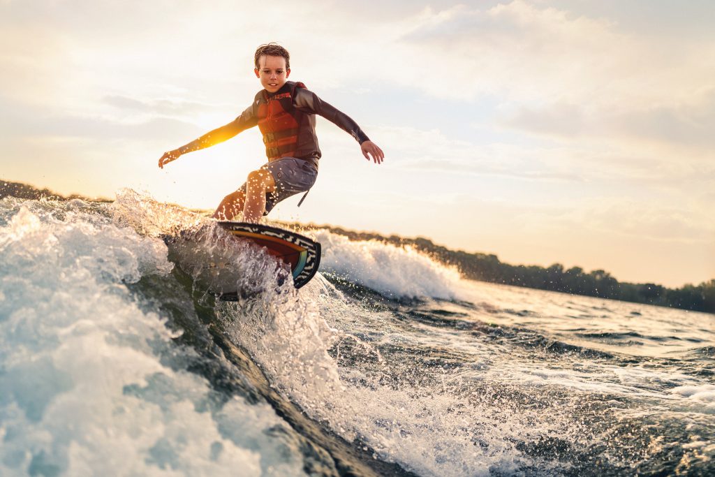 Kid wakesurfing at sunset