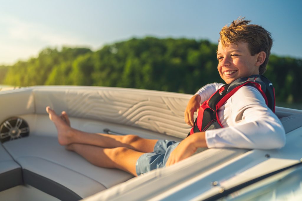 Kid sitting in the bow of an SDX 230 Surf
