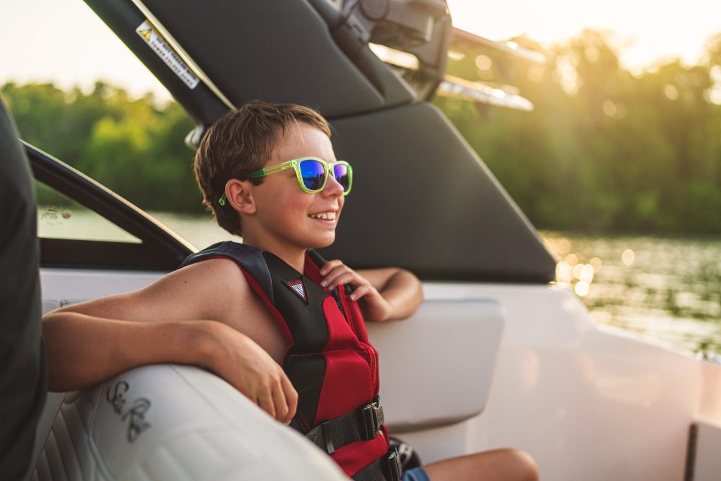Kid aboard an SDX 230 Surf at sunset