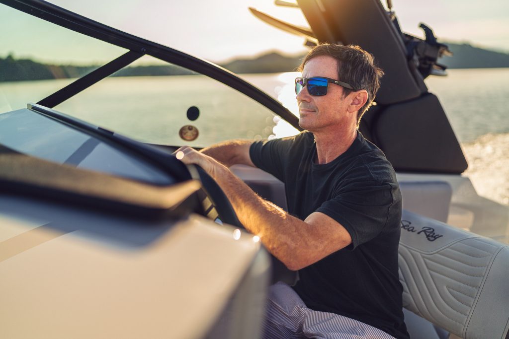 Man at the helm of an SDX 230 Surf at sunset