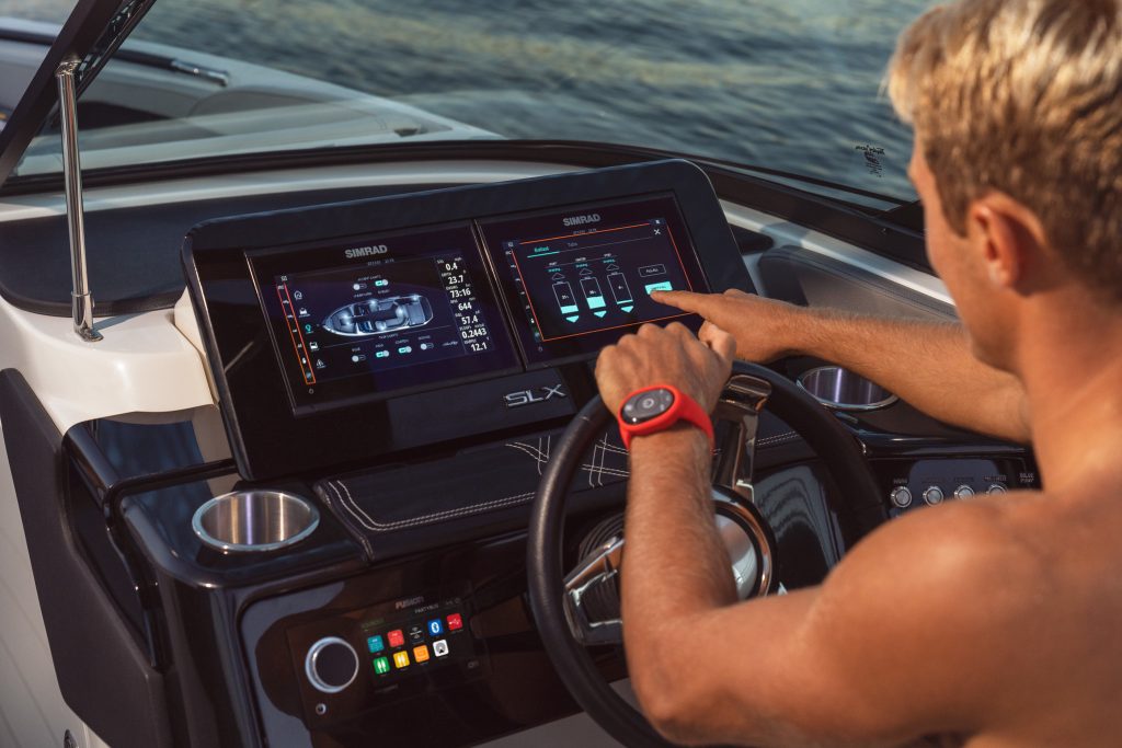 Man using a touchscreen display at the helm of an SLX 260 Surf