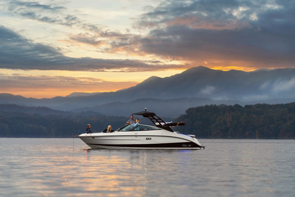Family aboard an SLX 260 Surf at sunset
