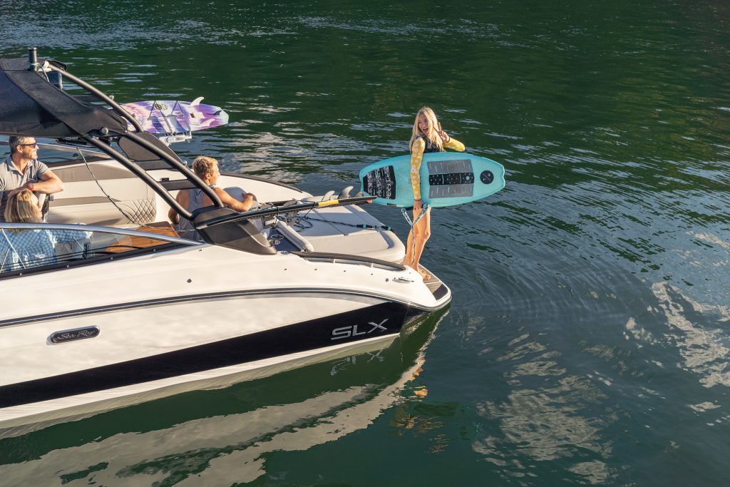 Woman with wakesurf board on an SLX 260 Surf