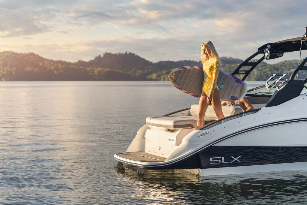 Woman with wakesurf board on an SLX 260 Surf