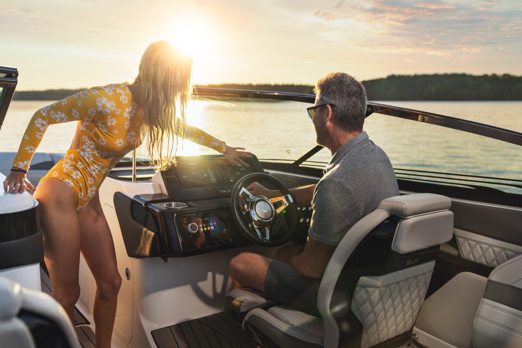 Father and daughter at the helm of an SLX 260 Surf at sunset
