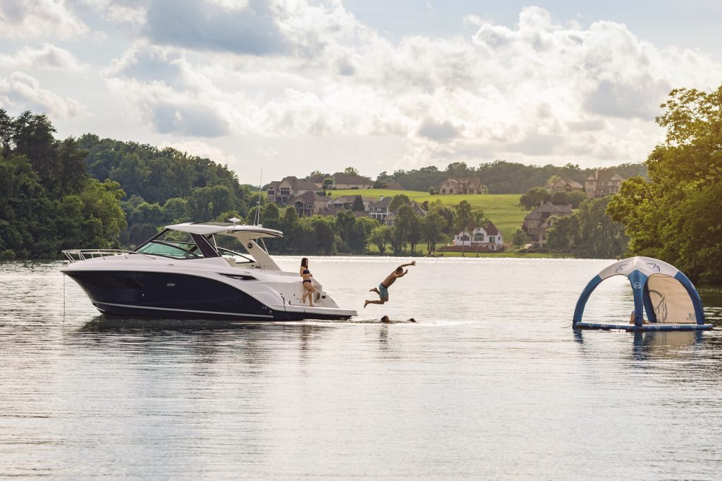 Family playing in the water around a Sundancer 320