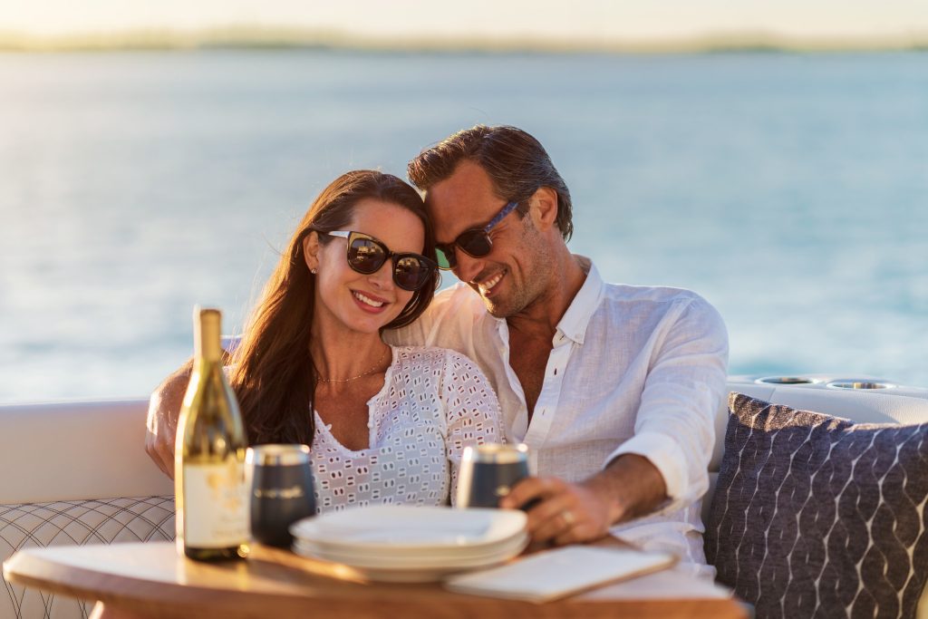 Couple sitting at the cockpit table in a Sundancer 370 Outboard
