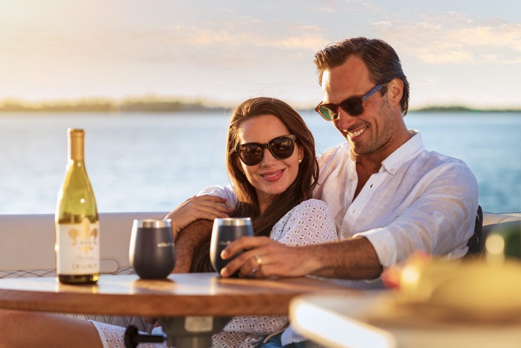 Couple sitting at the cockpit table in a Sundancer 370 Outboard